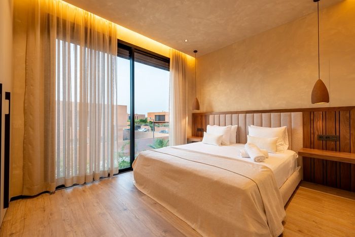Suite Atlas — la chambre et sa fenêtre d’angle sur les palmiers