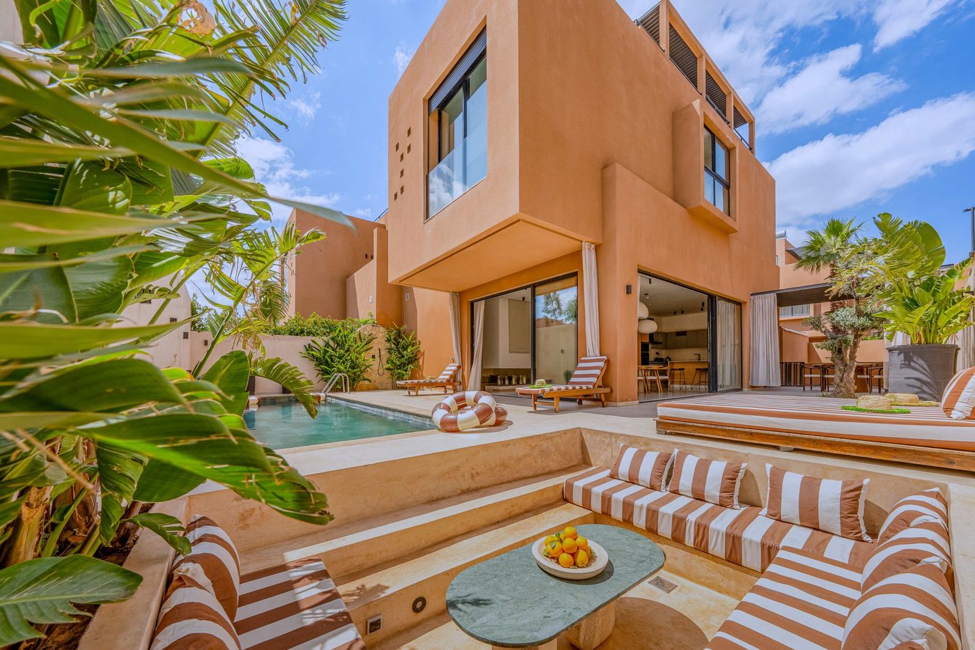 La Villa Camélia : sa façade ocre, sa piscine et son salon d’été sous les bananiers