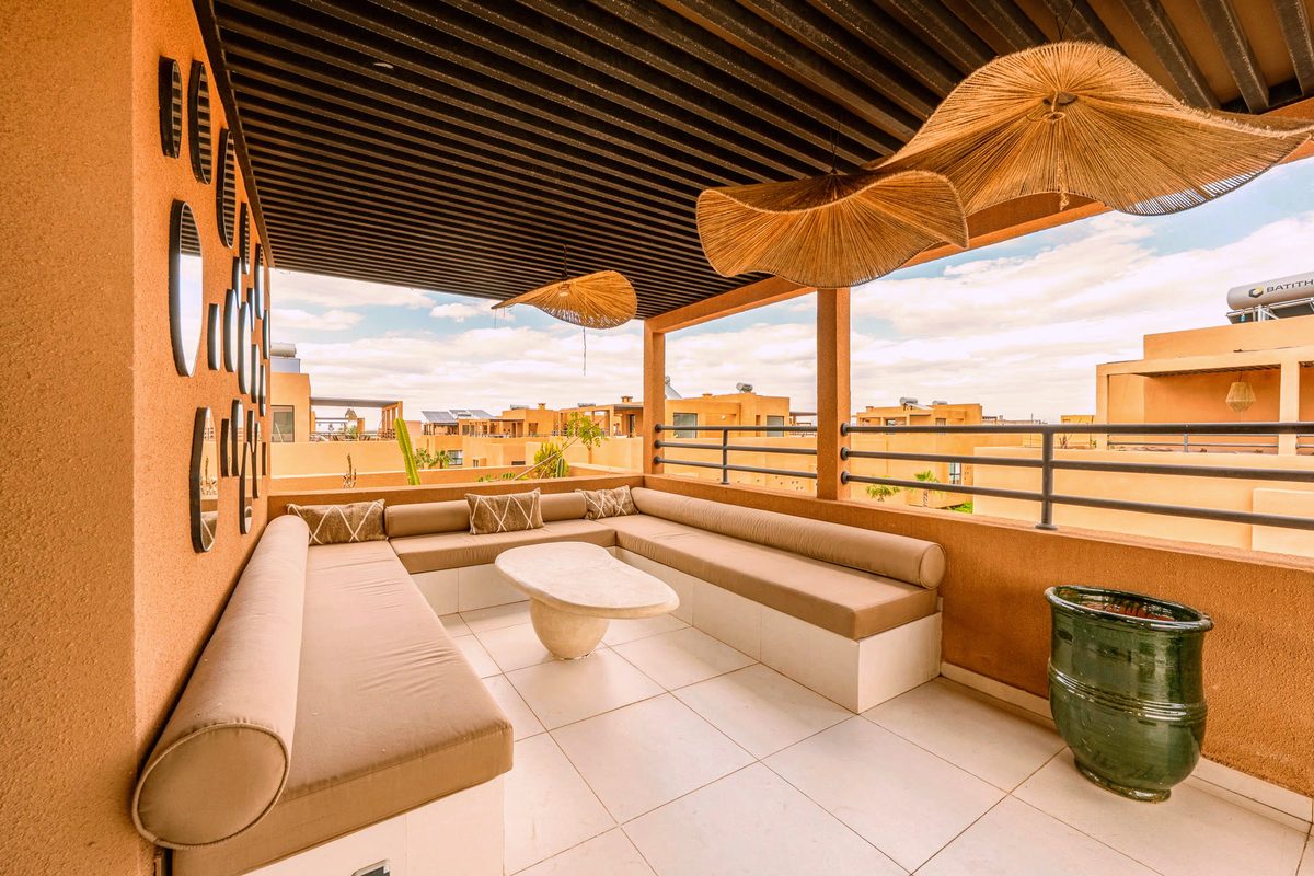 The rooftop at Villa Camélia, open to the palm trees and the peaks of the Atlas