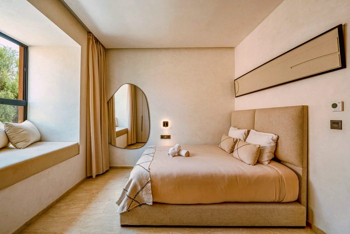 Sahara suite — the bedroom and its large organic-shaped mirror